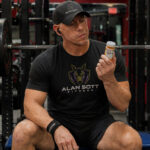 Man at gym holding a bottle of GLP-1s.