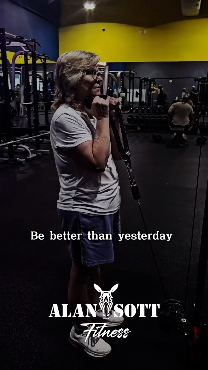 Woman, over 60, weight training with her personal trainer.